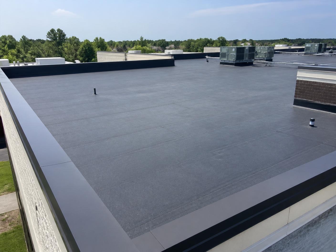 Commercial flat roof with new modified bitumen membrane and clean parapet wall flashing
